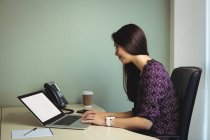 Empresaria Trabajando en el ordenador portátil en la oficina - foto de stock