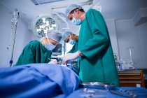 Grupo de cirurgiões que realizam operação no teatro de operação do hospital — Fotografia de Stock