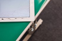 Primer plano de una tableta digital dañada en un centro de reparación - foto de stock