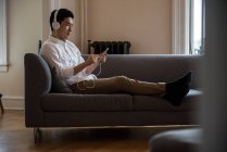 Mann hört zu Hause Musik auf digitalem Tablet — Stockfoto