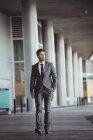 Uomo d'affari con un diario che cammina nel corridoio dell'edificio per uffici — Foto stock