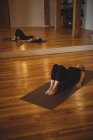 Donna che pratica yoga su tappetino in palestra — Foto stock