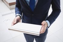 Обрізане зображення бізнесмена за допомогою цифрового планшета за межами офісної будівлі — стокове фото