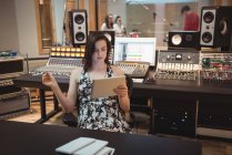 Аудиоинженер с помощью цифрового планшета в музыкальной студии — стоковое фото