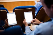 Dirigeants d'entreprise participant à une réunion d'affaires en utilisant une tablette numérique au centre de conférence — Photo de stock