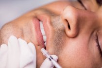 Homem a receber injeção de botox nos lábios na clínica — Fotografia de Stock