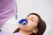 Female patient receiving teeth treatment at dental clinic — Stock Photo