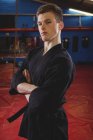 Karate-Spieler steht mit verschränkten Armen im Fitnessstudio — Stockfoto