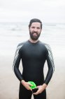 Portrait of athlete standing on wet beach — Stock Photo