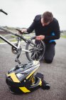 Велосипедист ремонтує велосипед BMX у скейтпарку — стокове фото