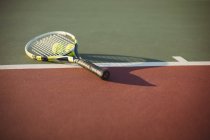 Close-up de raquete de tênis e bolas no campo — Fotografia de Stock