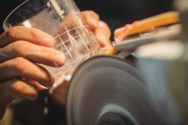 Крупный план полировки стеклодувов и шлифования стеклотары на стекольном заводе — стоковое фото