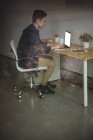 Бізнес-виконавчий, що працює на ноутбуці в офісі — стокове фото