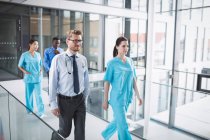 Врачи и медсестра идут по коридору в больнице — стоковое фото