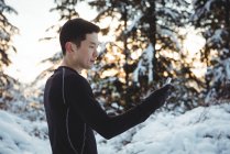 Mann in warmer Kleidung mit Handy im Winter — Stockfoto