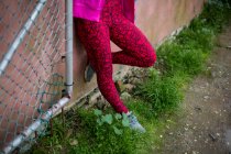 Baixa seção de parkour mulher de pé contra uma parede — Fotografia de Stock