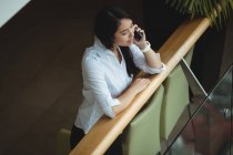 Businesswoman talking on mobile phone at office — Stock Photo