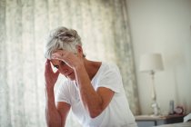 Preoccupata donna anziana in camera da letto a casa — Foto stock