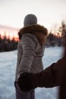 Пара стоїть і тримає руку на снігу покритій горі — стокове фото