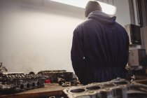 Vue arrière du mécanicien travaillant dans le garage de réparation — Photo de stock