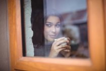 Задумчивая женщина выпивает чашку кофе в кафе — стоковое фото