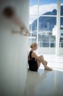 Bailarina deprimida sentado contra a parede no estúdio — Fotografia de Stock