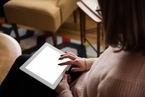 Partie médiane de la femme utilisant une tablette numérique dans le salon à la maison — Photo de stock