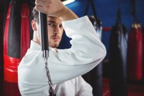 Портрет игрока в карате, практикующего с нунчаком в фитнес-студии — стоковое фото