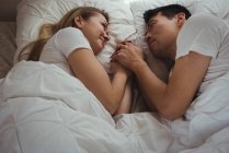 Casal romântico deitado na cama no quarto — Fotografia de Stock
