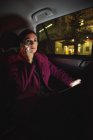 Красивая деловая женщина с цифровым планшетом разговаривает по телефону в машине — стоковое фото