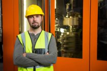 Portrait of confident male worker standing against door at factory — Stock Photo
