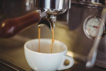 Gros plan de l'espresso coulant de la machine à café dans le café — Photo de stock
