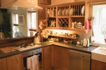 Порожня кухня вдома з посудом в шафі і техніці — стокове фото