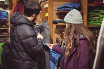 Couple selecting apparel together in a clothes shop — Stock Photo