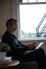 Mann benutzt Handy und digitales Tablet im heimischen Wohnzimmer — Stockfoto