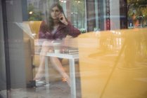 Деловая женщина разговаривает по мобильному телефону в офисе — стоковое фото