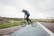 Ciclista preparándose para BMX Racing en rampa de salida en skatepark - foto de stock