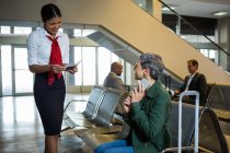 Flugbegleiter bei der Passkontrolle am Check-in-Wartebereich am Flughafen — Stockfoto