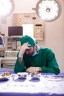 Напружений хірург сидить в операційній кімнаті в лікарні — стокове фото