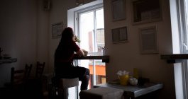 Вид ззаду жінки, що п'є медичний напій у кафе — стокове фото