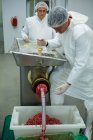 Açougueiros usando máquina de picar carne na fábrica de carne — Fotografia de Stock