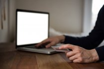 Мужчина делает онлайн покупки на ноутбуке дома — стоковое фото