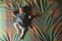 Niedliches Baby auf dem Bett liegend im Schlafzimmer zu Hause, Blick über den Kopf — Stockfoto