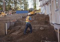 Строитель работает с лопатой на строительной площадке — стоковое фото