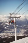 Низкий угол обзора трех лыжников, путешествующих в подъемнике на горнолыжном курорте — стоковое фото