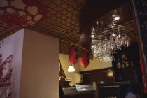 Verres à vin suspendus au comptoir du bar au restaurant — Photo de stock