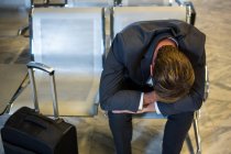 Бизнесмен отдыхает в зоне ожидания в терминале аэропорта — стоковое фото