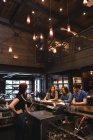 Bartender interacting with customers at bar counter — Stock Photo
