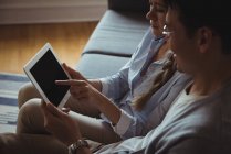 Coppia utilizzando tablet digitale in soggiorno a casa — Foto stock