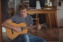 Hombre tocando la guitarra en casa - foto de stock